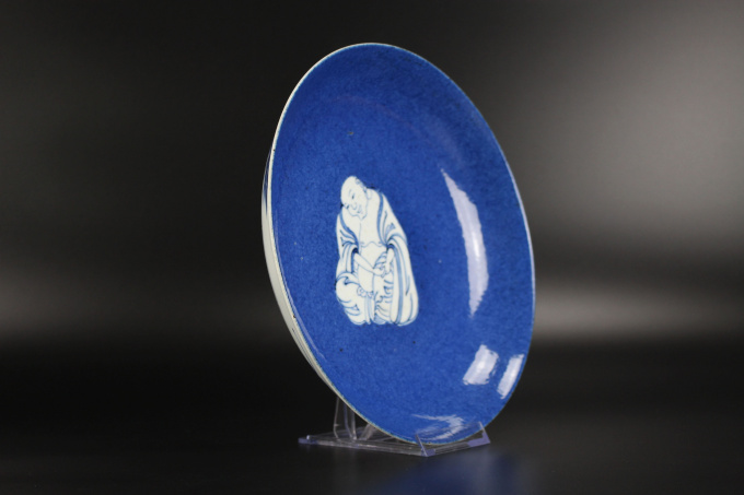 A Chinese powder-blue-ground blue and white ‘Budai’ dish, Kangxi period by Artiste Inconnu